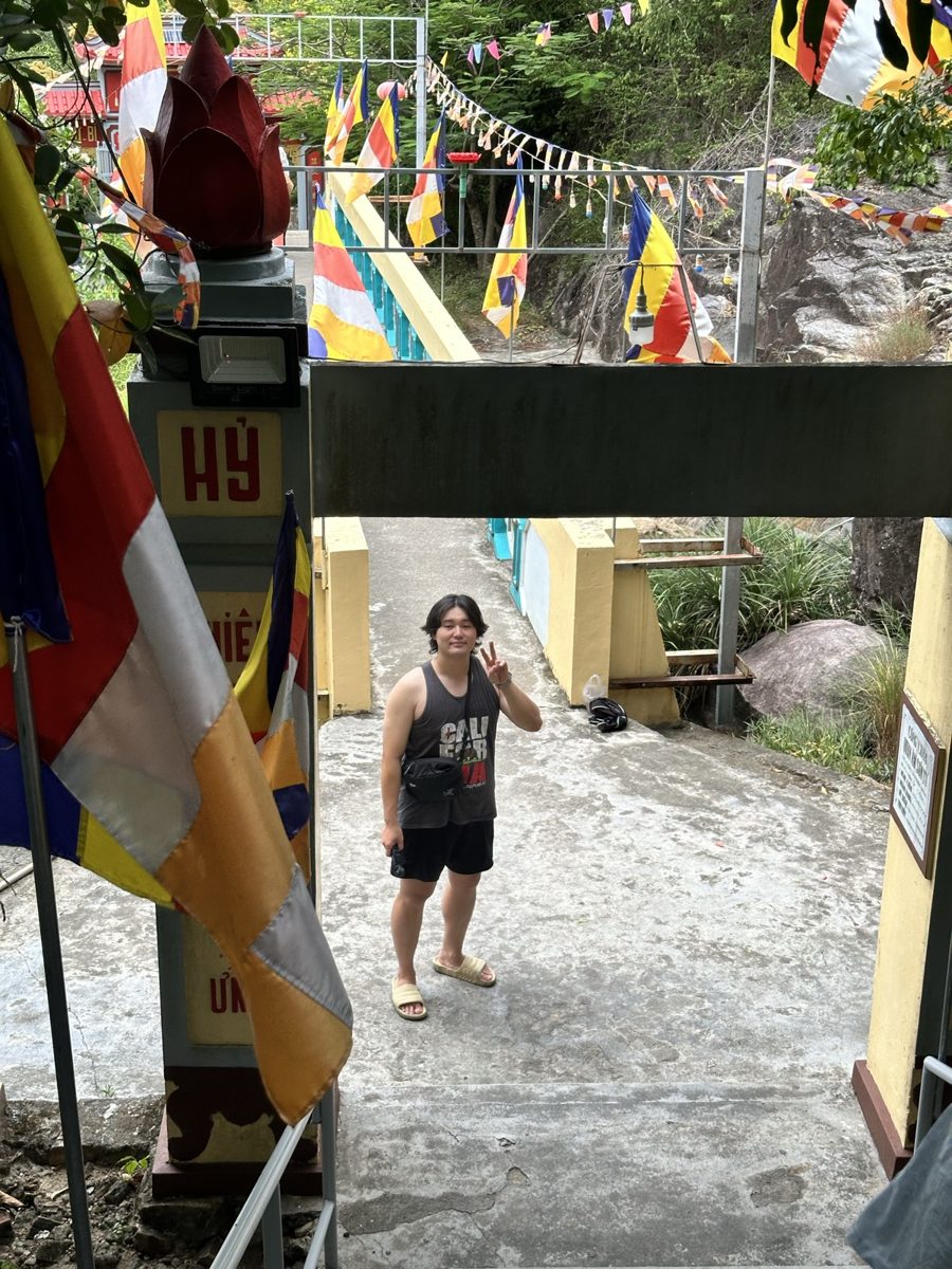 Eddie standing on an outdoor path beneath colourful flags